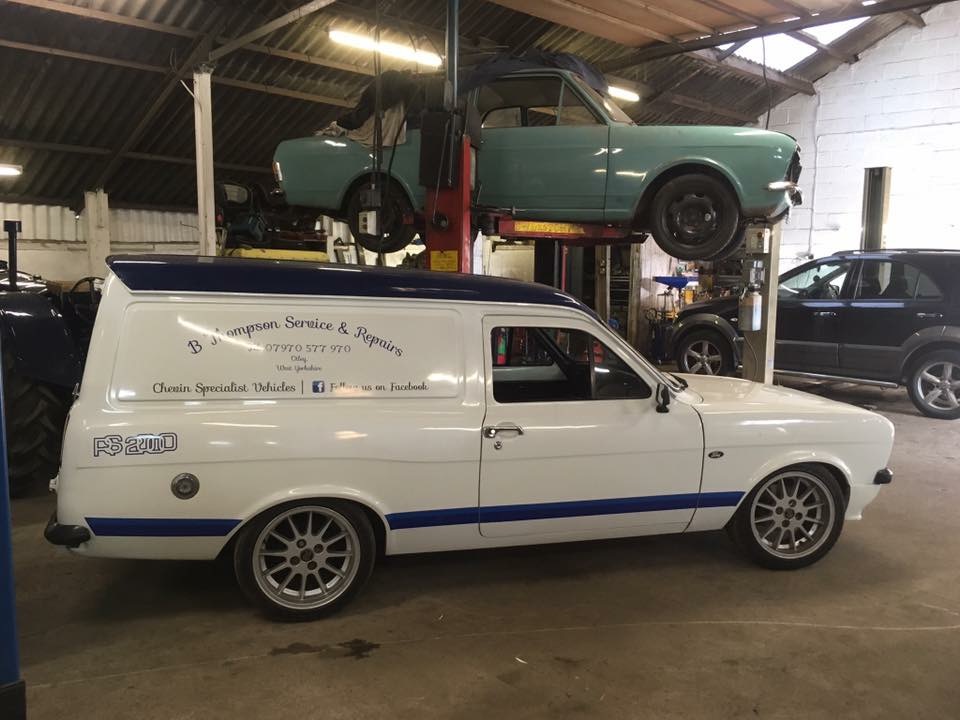 Inside Crossgate Garage, with a classic car on the lift and a Chevin Specialist Vehicles van
